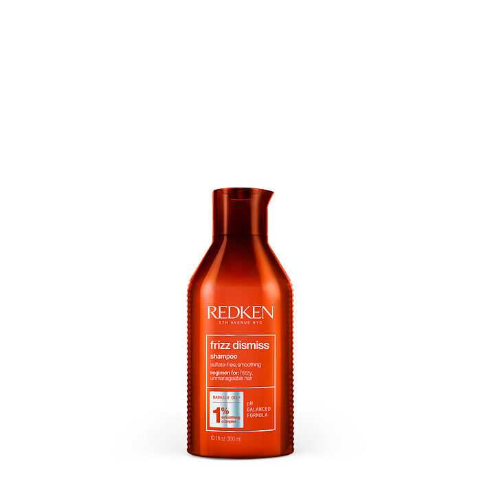 Redken Frizz Dismiss Shampoo with anti-humidity protection in an orange bottle.